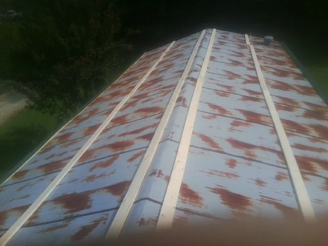 Rusted metal roof panels with new wood purlins before replacement — Storm Damage Roof Repair in Hope by Roofing Brothers